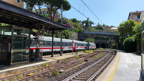 Train-departing-train-station-heading-into-tunnel-with-passengers-in-Italy