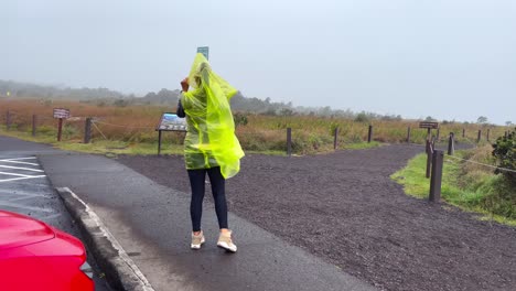 Woman-in-rain-on-outside-of-Mauna-Loa-volcano-rim-in-Hawaii,-cloudy-day