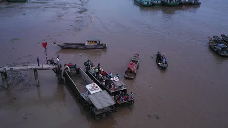 Aerial-view-of-maritime-workers-boarding-small-boats-at-Saigon-River-jetty,-Vietnam