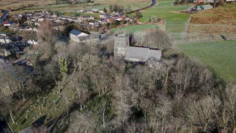 Aerial-footage-of-the-village-of-Denshaw,-and-the-old-church-and-graveyard,-a-typical-rural-village-in-the-heart-of-the-Pennines