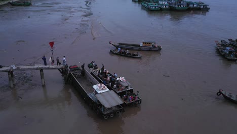Aerial-view-of-maritime-workers-boarding-small-boats-at-Saigon-River-jetty,-Vietnam