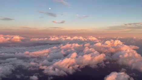 Front-view-from-the-cabin-of-a-commercial-plane-in-flight-at-sunset-flying-over-the-clouds