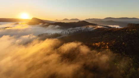 Short-cinematic-footage-recorded-at-the-sunrise-with-a-beautiful-view-of-the-fog-flowing-above-a-mountain