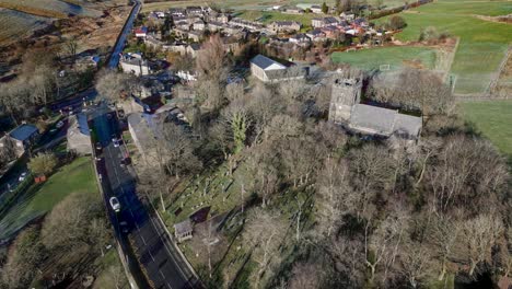 Aerial-footage-of-the-village-of-Denshaw,-and-the-old-church-and-graveyard,-a-typical-rural-village-in-the-heart-of-the-Pennines