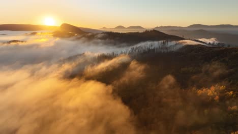 Filmkulisse-Am-Morgen-Während-Des-Sonnenuntergangs,-Während-Der-Nebel-über-Den-Wald-Strömt