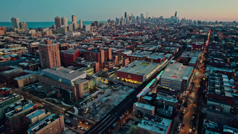 orbiting-cta-holiday-train-decorated-in-chistmas-on-Brown-Lane-railroad-and-tilting-up-with-an-epic-chicago-skyline-view-at-sunset-4k