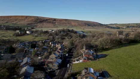 Aerial-footage-of-the-village-of-Denshaw,-and-the-church-and-graveyard,-a-typical-rural-village-in-the-heart-of-the-Pennines