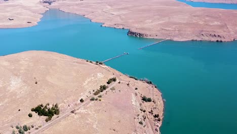 Aerial-drone-shot-of-the-beautiful-blue-waters-of-the-Driefkloof-Dam,-the-surrounding-veld-landscape-is-dry,-dusty-and-lifeless,-Free-State,-South-Africa