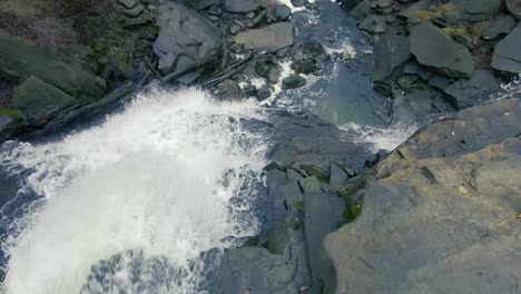Slow-camera-pan-from-top-of-waterfall-down-below