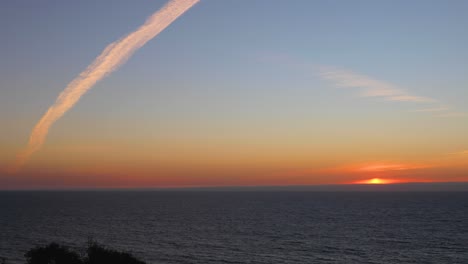Sonnenuntergang-Im-Zeitraffer-Mit-Den-Ozean--Und-Flugzeugwolken