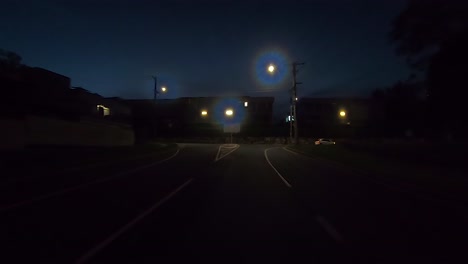 Rear-facing-night-driving-point-of-view-POV-for-interior-car-scene-green-screen-replacement---left-turn-along-quiet-city-backroads-with-warehouses