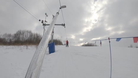 Skifahrer-Gleiten-Auf-Dem-T-Bar-Lift-Im-Wintersportort-Die-Piste-Hinauf