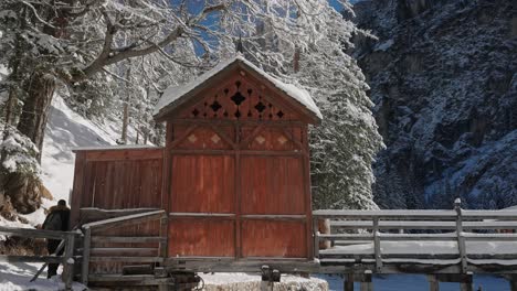 Wooden-mountain-hut-on-the-frozen-surface-of-Lake-Braies,-in-the-snowy-Dolomites,-Italian-Alps
