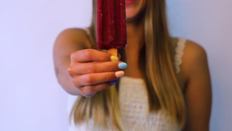Smiley-girl-holding-a-red-icecream-with-colorful-nails