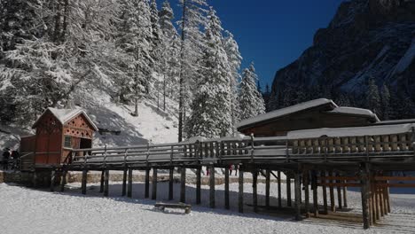 Wooden-mountain-house-on-the-frozen-surface-of-Lake-Braies,-in-the-snowy-Dolomites,-Italian-Alps
