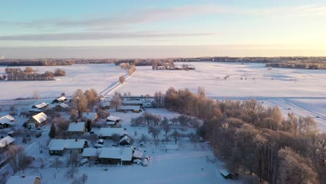 Snow-Covered-Small-Rural-Village,-Aerial-View-on-Sunny-Winter-Day---Dolly-In