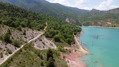 Congost-de-Mont-Rebei-Canyon-at-Ager,-Catalonia-and-Aragon,-Spain---Aerial-Drone-View-of-the-Hiking-Trail,-Blue-Noguera-Ribagorzana-River-and-Green-Mountains