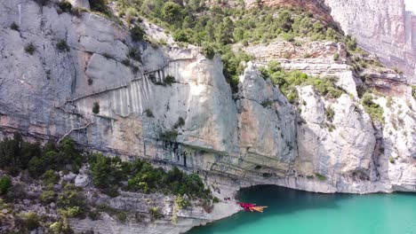 Pasarelas-de-Montfalco-and-Congost-de-Mont-Rebei-Canyon-at-Catalonia-and-Aragon,-North-Spain---Aerial-Drone-View-of-Kayaks-at-the-Noguera-Ribagorzana-River-and-Dangerous-Stairs-along-the-Steep-Cliffs