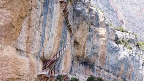 Pasarelas-de-Montfalco-Hike-at-Congost-de-Mont-Rebei-Canyon,-Catalonia-and-Aragon,-North-Spain---Aerial-Drone-View-of-the-Dangerous-Scary-Stairs-along-the-Steep-Cliffs