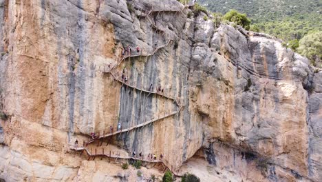 Pasarelas-de-Montfalco-at-Congost-de-Mont-Rebei-Canyon,-Catalonia-and-Aragon,-North-Spain---Aerial-Drone-View-of-Tourists-walking-the-Scary-Stairs-and-Hiking-Trail-along-the-Steep-Cliffs