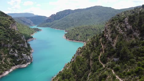 Congost-De-Mont-Rebei-Canyon-Bei-Ager,-Katalonien-Und-Aragon,-Spanien---Luftdrohnenansicht-Des-Blauen-Flusses-Noguera-Ribagorzana,-Des-Wanderweges-Und-Der-Grünen-Berge