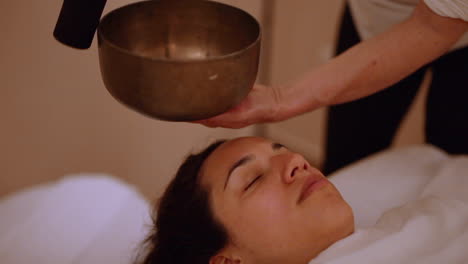 Seelenbeugende-Tibetische-Klangschale-Neben-Schlafendem-Massagekunden