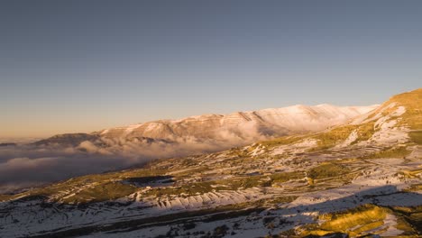 Toma-Aérea-De-Hiperlapso-De-Drones-Para-Cadenas-Montañosas-Con-Nubes-En-Movimiento-Durante-El-Invierno-En-Un-Día-Soleado-Y-Nevado,-Hora-Del-Atardecer,-Cadenas-Montañosas-Occidentales-Del-Norte-De-Líbano