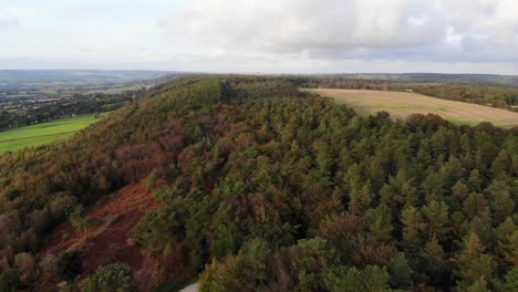 Aerial-descending-shot-of-East-Hill-strip-Devon-England-showing-the-autumn-colors-of-the-trees