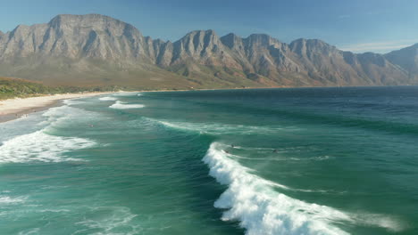 Aerial-View-Of-Surfers-In-The-Ocean-At-Kogel-Bay-Beach,-Cape-Town---drone-shot