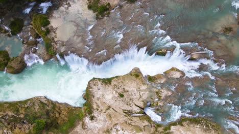 Aerial-top-down-shot-of-waterfall-cascading-over-canyon,-Mexico-travel