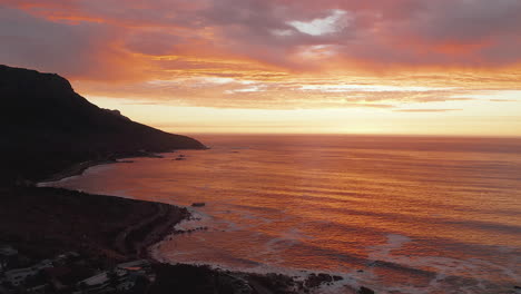 Beautiful-Seascape-View-With-Orange-Sunset-At-Bakoven-Beach,-Cape-Town-In-South-Africa