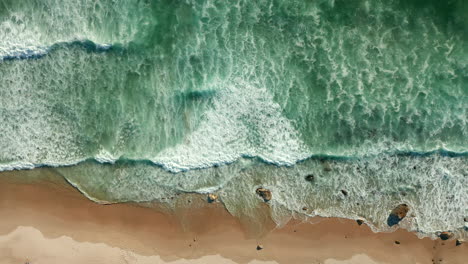 Foamy-Sea-Waves-Splashing-On-Sandy-Shore-At-Kogel-Bay-Beach,-Cape-Town,-South-Africa---aerial-top-down