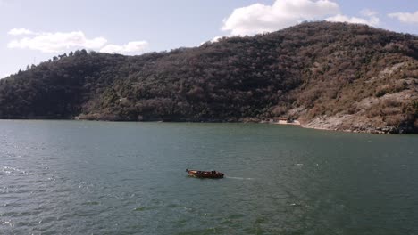 AERIAL---Boat-ride-on-beautiful-Lake-Skadar,-Montenegro,-spinning-shot