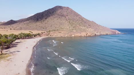 Los-Genoveses-Beach-at-Cabo-de-Gata,-Almeria,-Andalucia,-Spain---Aerial-View-of-Tourists-at-the-Sandy-Beach-and-Vulcanic-Landscape