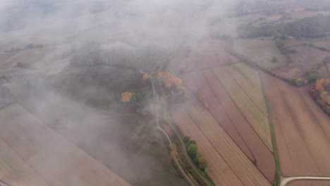 Flying-through-mist-above-Tuscany-rural-countryside,-aerial
