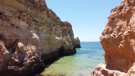 Praia-Dos-Tres-Irmaos-Strand,-Algarve,-Portugal---Luftdrohnenschuss,-Der-Entlang-Der-Felsformationen-Am-Strand-Fliegt