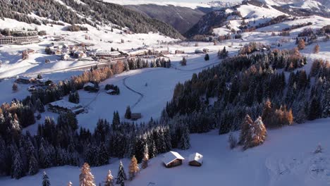 Snowy-mountain-countryside-during-sunrise,-Italian-ski-resort-Alpe-Di-Siusi,-aerial