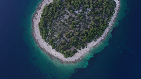 Small-natural-Mediterranean-island-surrounded-by-blue-water,-aerial,-Otocic-Smokvica-Vela