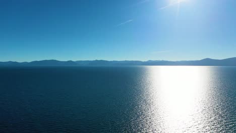 Agua-Reluciente-Con-Reflejo-De-La-Luz-Del-Sol-En-El-Lago-Tahoe-En-California,-Estados-Unidos-Y-Montañas-En-El-Fondo