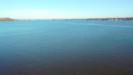 Flying-Over-Calm-Blue-Water-With-Ripples-From-Wind-On-Lake-Of-The-Ozarks-in-Midwest-Missouri-At-Daytime---aerial-drone-shot