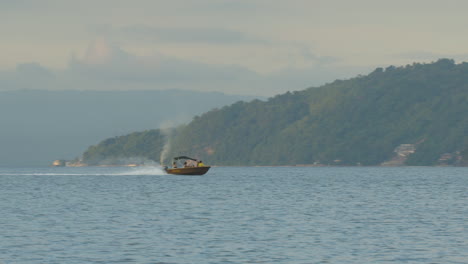 Long-Shot-Of-A-Small-Speed-Boat-Entering-A-Cove-In-A-Remote-Island