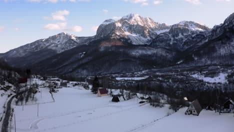 AERIAL---Beautiful-snowy-winter-on-a-farm,-Kolasin,-Montenegro,-rising-reveal