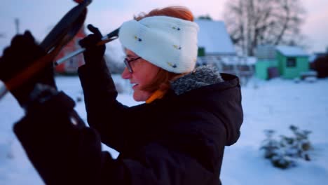 Senior-Woman-Having-Fun-Skiing-In-Snow-Covered-Road-In-A-Village-In-Lithuania