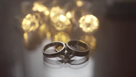 Wedding-rings-displayed-elegantly-with-bokeh-lighting-and-smoke-passing-by