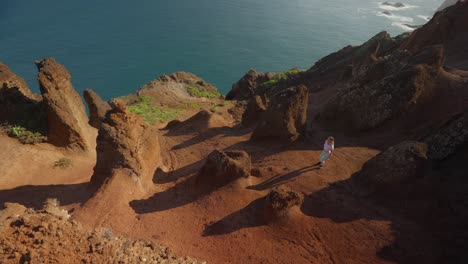 Brave-woman-on-adventure-in-erosion-formed-sandstone-terrain-on-high-coastal-cliffs-of-Madeira
