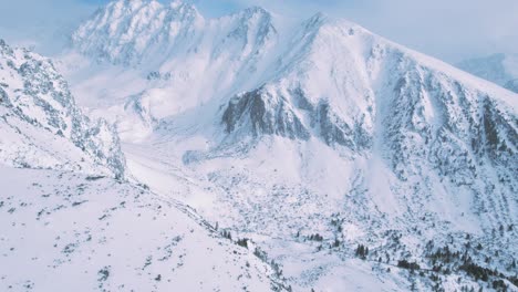 Aerial-winter-snowy-mountain-range-with-ski-resort-at-High-Tatra,-Slovakia
