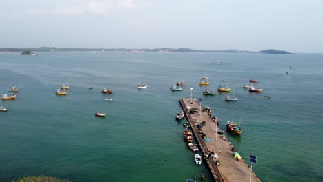 Orbit-Shot-Of-Different-Fishing-Boats-Anchored-In-Weligama-harbor-In-Calm-Blue-Ocean,-Sri-Lanka