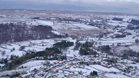 North-York-Moors-National-Park,-aerial-flight-over-Castleton,-reverse-movement,-with-pan-down-onto-Castleton-town