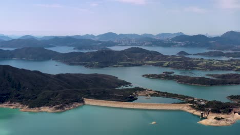Aerial-dolly-in-of-High-Island-Reservoir-verdant-islets-and-hills-surrounded-by-turquoise-water,-San-Kung-Peninsula-in-Hong-Kong,-China