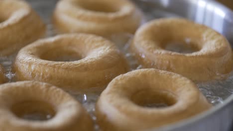 Close-up-of-fresh-golden-donuts-frying-in-hot-oil